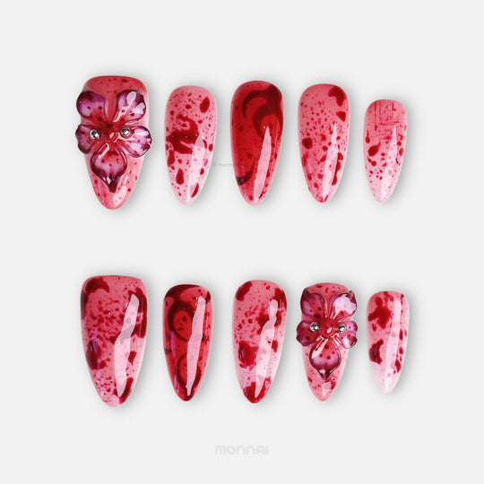 999 Roses press-on nails laid out in close-up, pink and red splatter design with 3D gothic flowers and glossy finish.