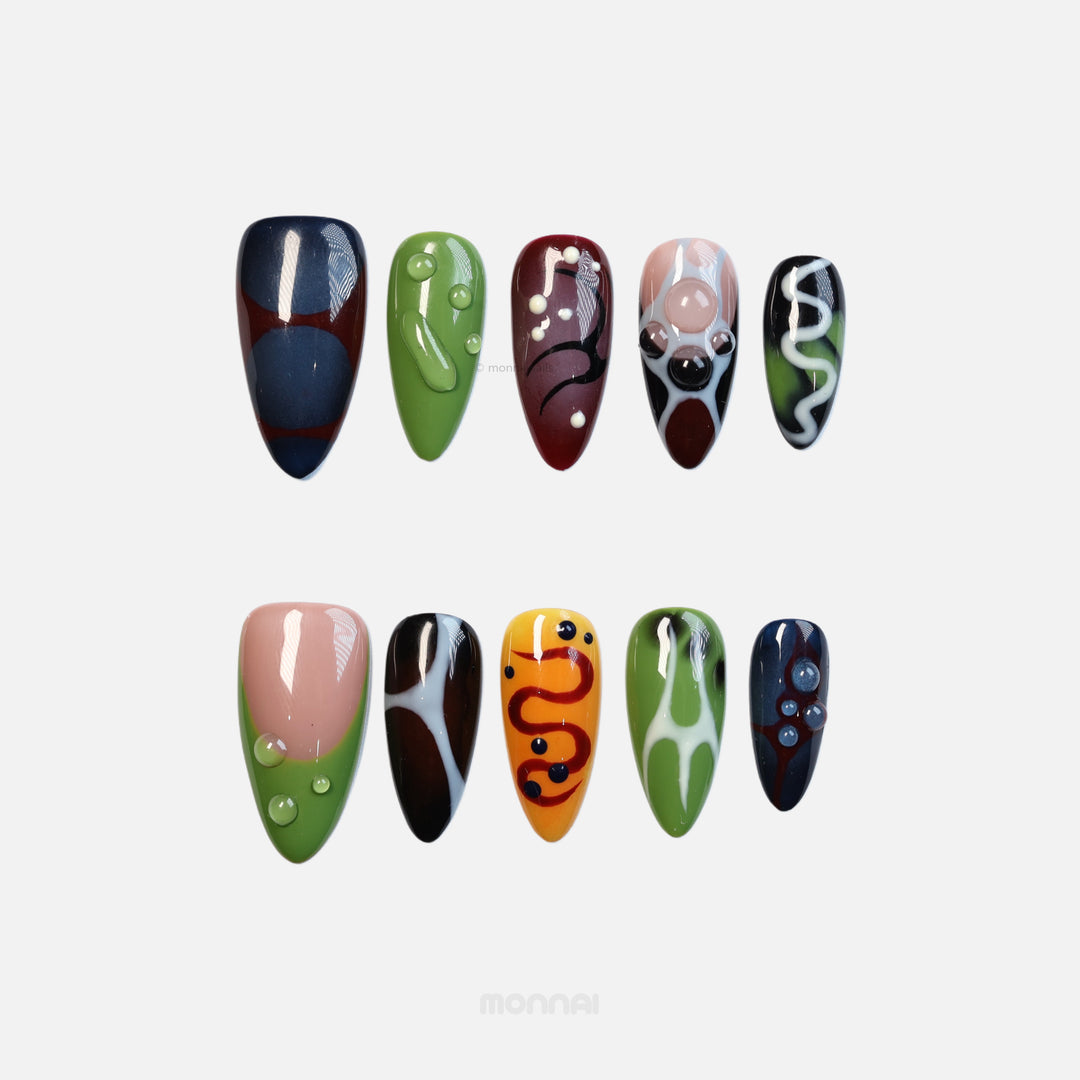 Abstract Flow press-on nails laid out in bold abstract colors, wavy lines, and clear 3D dewdrop accents.