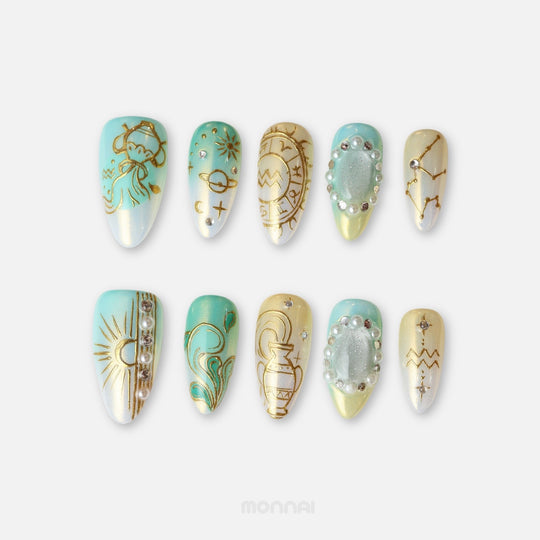 Aquarius press on nails from the Zodiac Collection, featuring aqua and champagne tones, gold celestial details, pearls and constellation motifs.