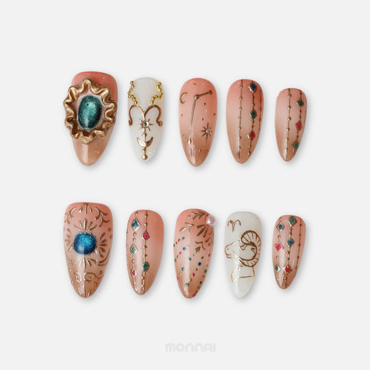 Aries press on nails from the Zodiac Collection, featuring terracotta tones, gold ram motifs, constellation details and colourful jewel accents.