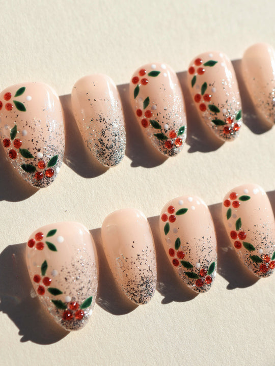 Berry Frost Christmas-themed press-on nails laid out with silver glitter gradient, berry vines, and ruby rhinestones.