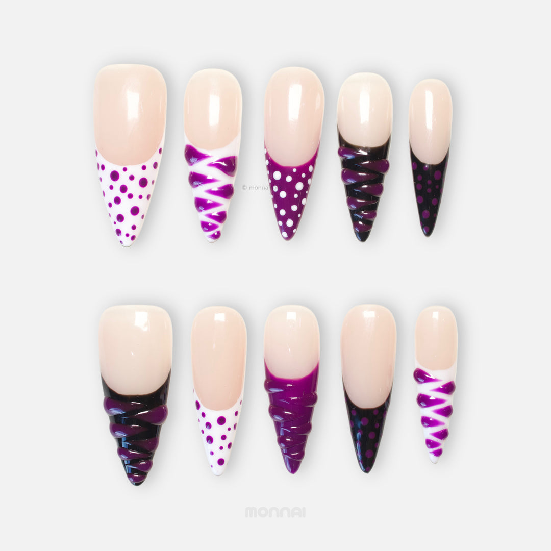 Berry Spin press-on nails shown in close-up with sheer nude base, purple polka dots, black French tips, and 3D gel swirl details.