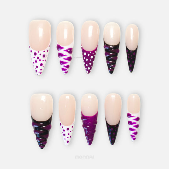 Berry Spin press-on nails shown in close-up with sheer nude base, purple polka dots, black French tips, and 3D gel swirl details.