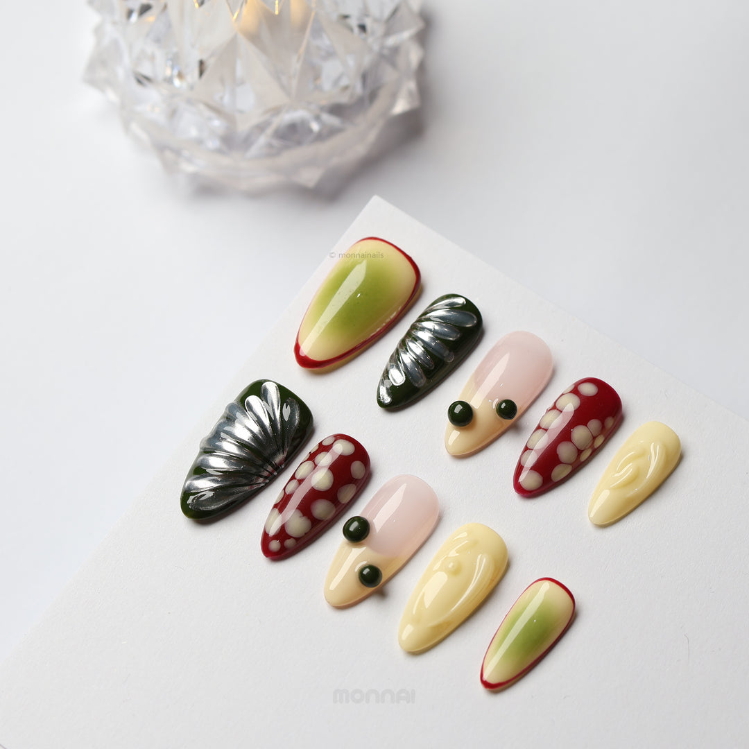 Berry press-on nails laid out, mixed abstract set with cream, nude, red, green and glossy dotted accents