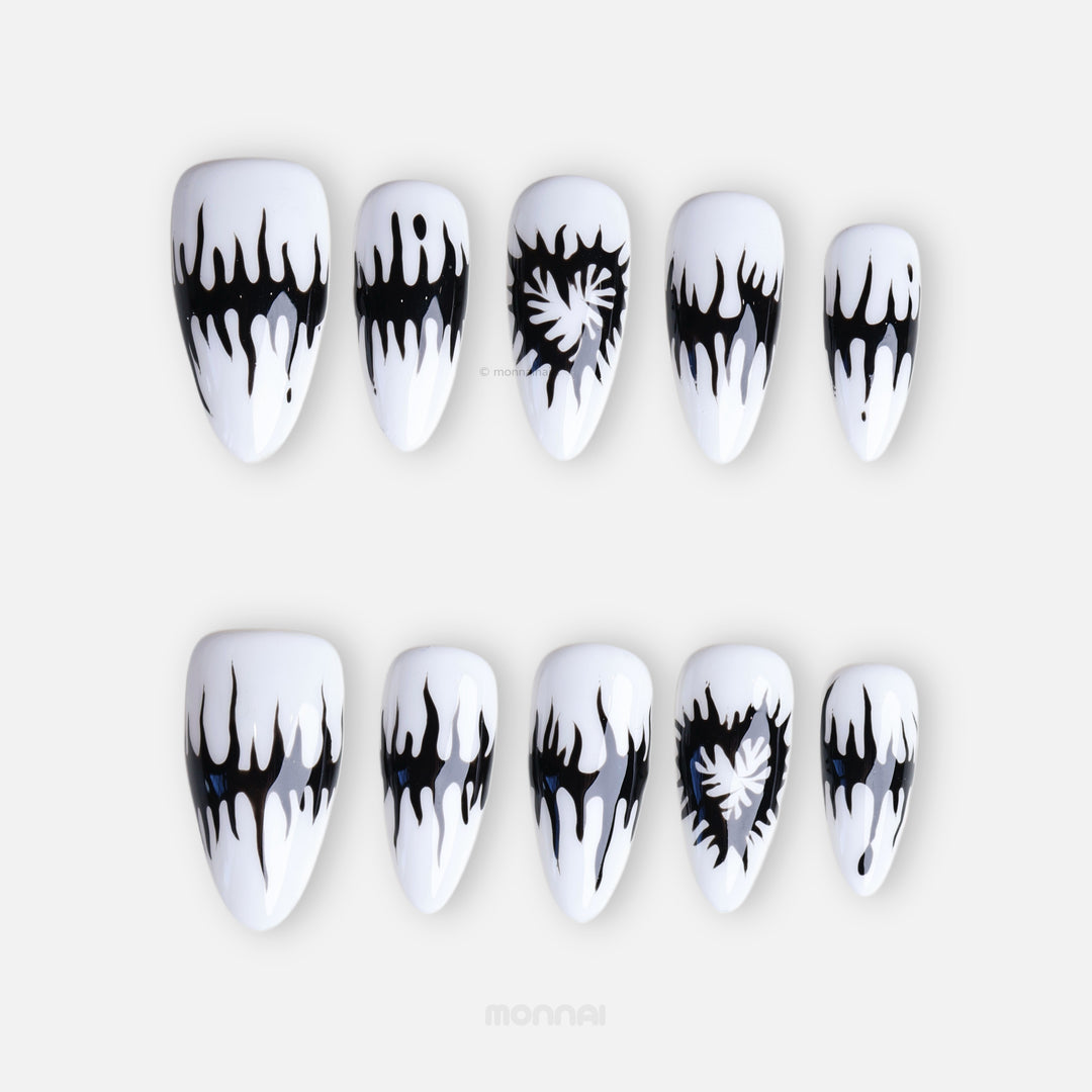 Black or White press-on nails with black melting spikes, heart motifs, and a glossy finish shown laid out.