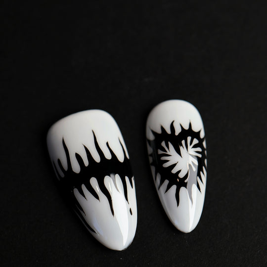 Black or White press-on nails with black melting spikes and a heart motif, shown in close-up.