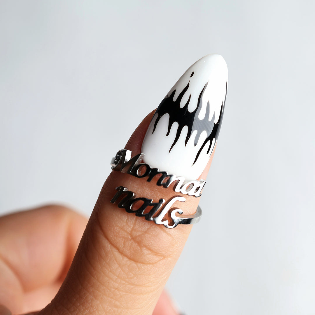 Black or White press-on nails on a hand, showing white and black melting spikes with a glossy finish