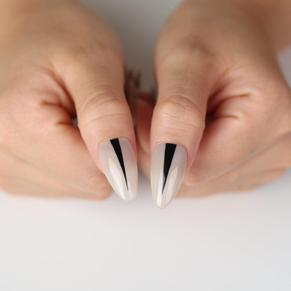 Black Dagger minimalist press on nails with tapered black stripe on creamy nude base, highlighting quiet confidence.