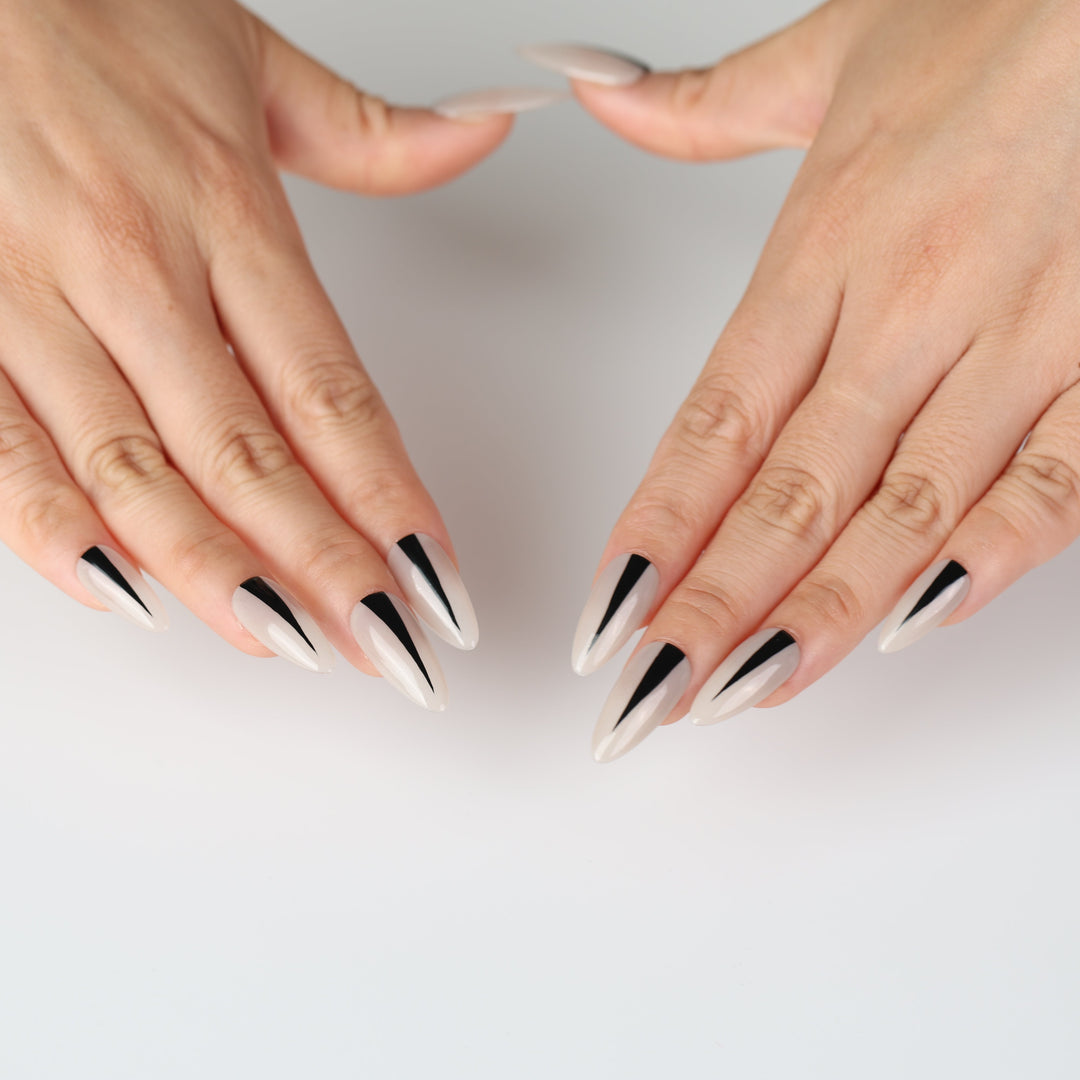 Black Dagger press on nails featuring a creamy nude base with tapered black stripes for a minimalist look.