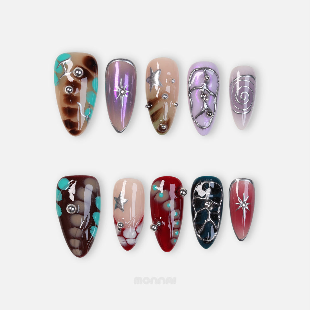 Blade Runner press-on nails laid out with crocodile texture, metallic silver accents, stars and rhinestones