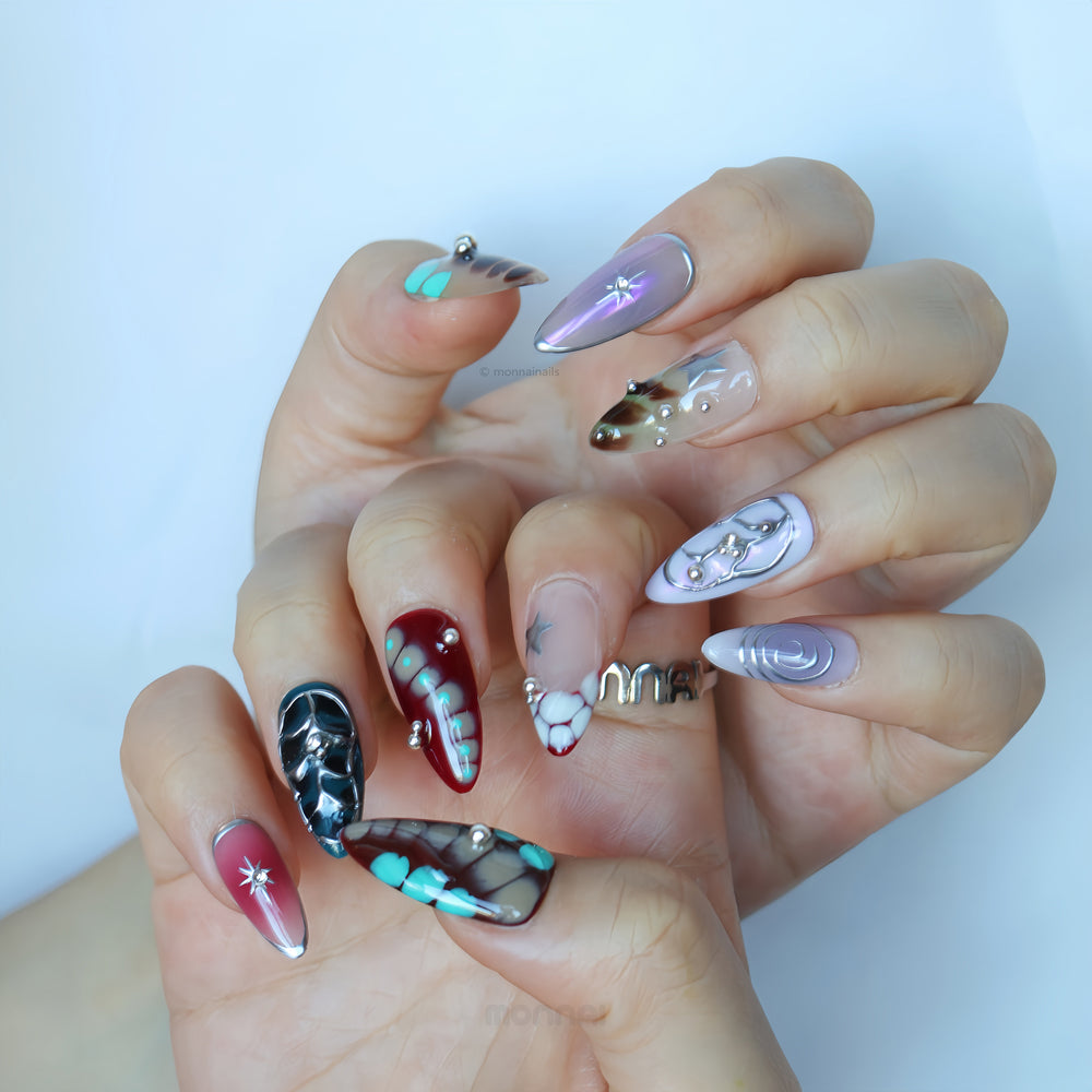 Blade Runner press-on nails worn on hand with crocodile texture, metallic silver accents, star details and rhinestones