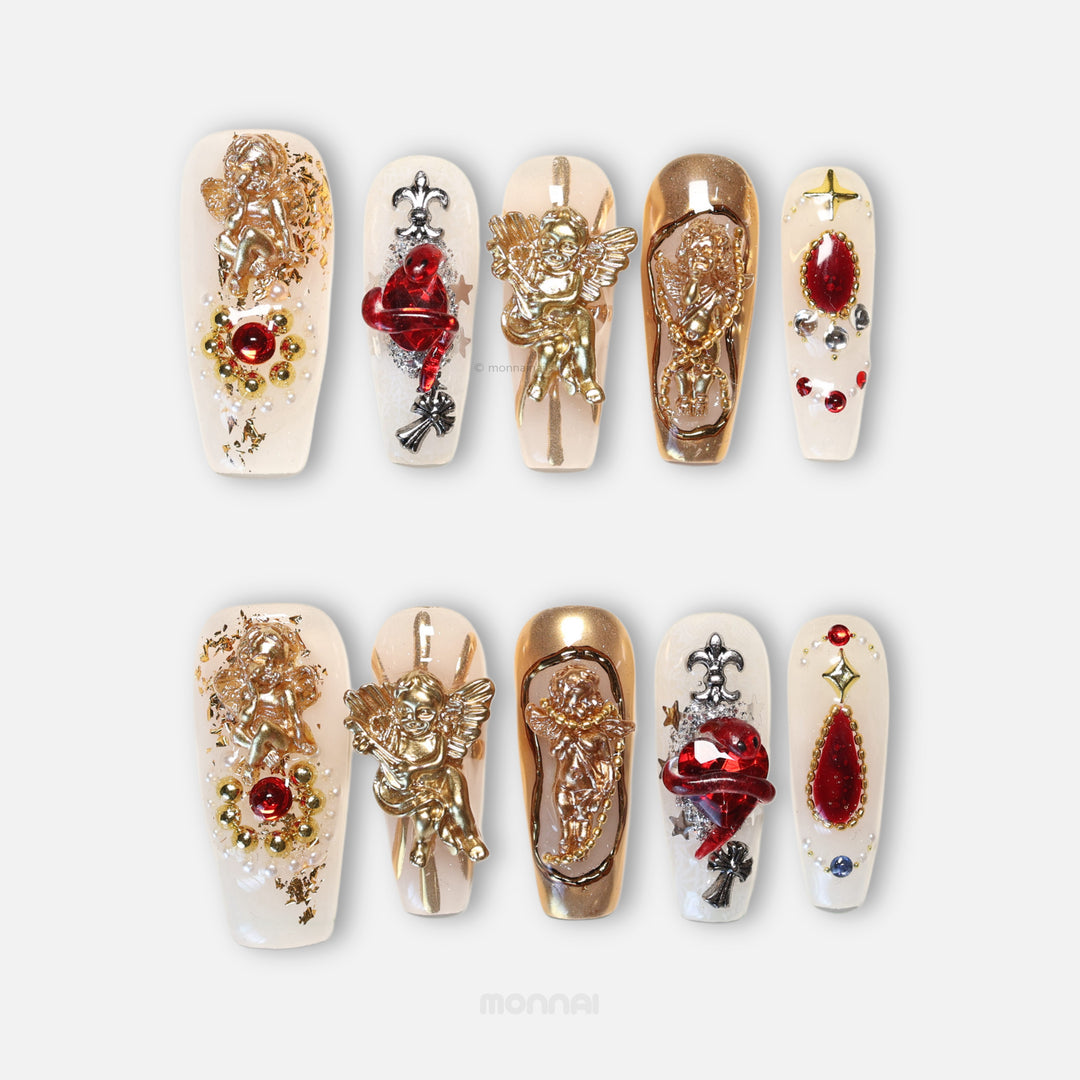 Blood Oath press-on nails shown laid out with gothic cathedral-style gold cherubs, ruby-red jewels, and metallic framing