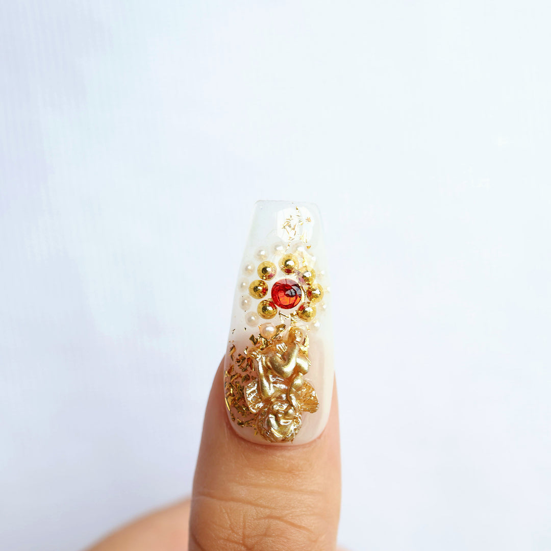 Blood Oath press-on nails close-up with gold foil, ruby jewel and pearl accents in a gothic cathedral style
