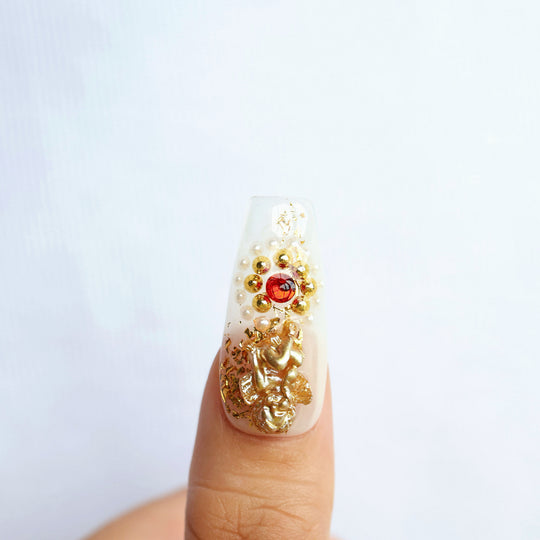Blood Oath press-on nails close-up with gold foil, ruby jewel and pearl accents in a gothic cathedral style
