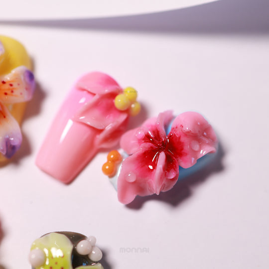 Blooming Paradise press-on nails in close-up, featuring pink floral 3D details, glossy dewdrops, and bright airbrush accents.