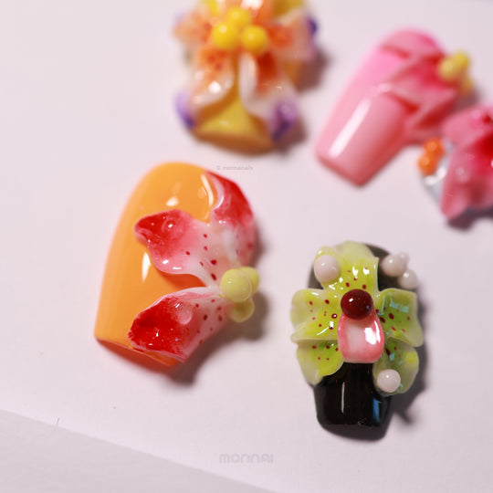 Blooming Paradise press-on nails with glossy floral 3D accents, shown in close-up with bright orange, pink, and lime details