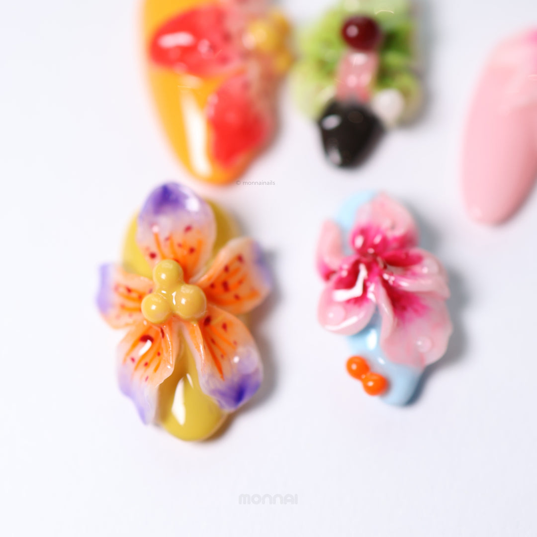 Blooming Paradise press-on nails laid out close-up with colorful 3D floral accents and glossy dewdrops