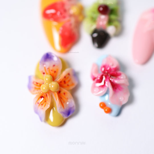 Blooming Paradise press-on nails laid out close-up with colorful 3D floral accents and glossy dewdrops