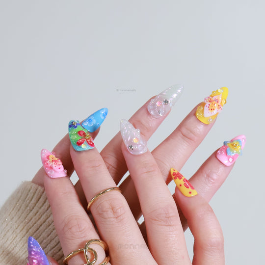 Blossom Fantasy press-on nails worn on hands, with pastel floral art, 3D flowers, and dewdrop pearl accents