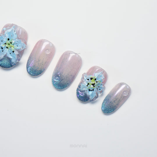 Blue Ice press-on nails laid out with icy gradient cat-eye shimmer and translucent blue 3D flowers