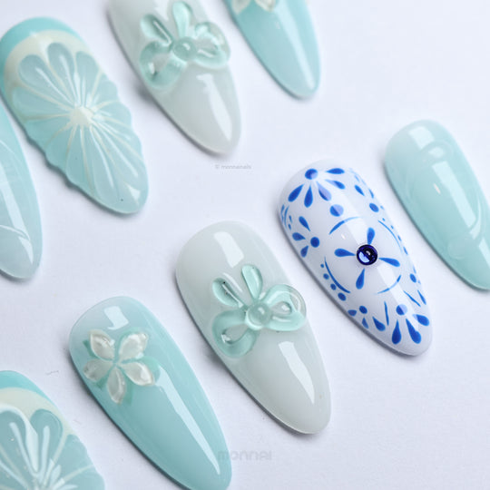 Blue Porcelain press-on nails laid out with pale blue boho floral accents and subtle 3D details.