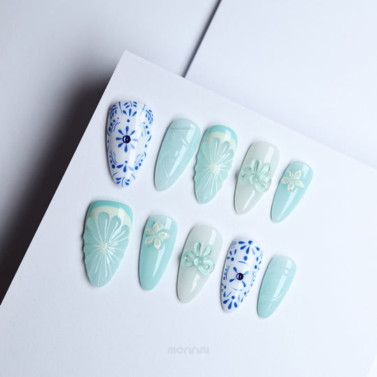 Blue Porcelain press-on nails laid out in soft blue tones with boho floral patterning and subtle 3D accents