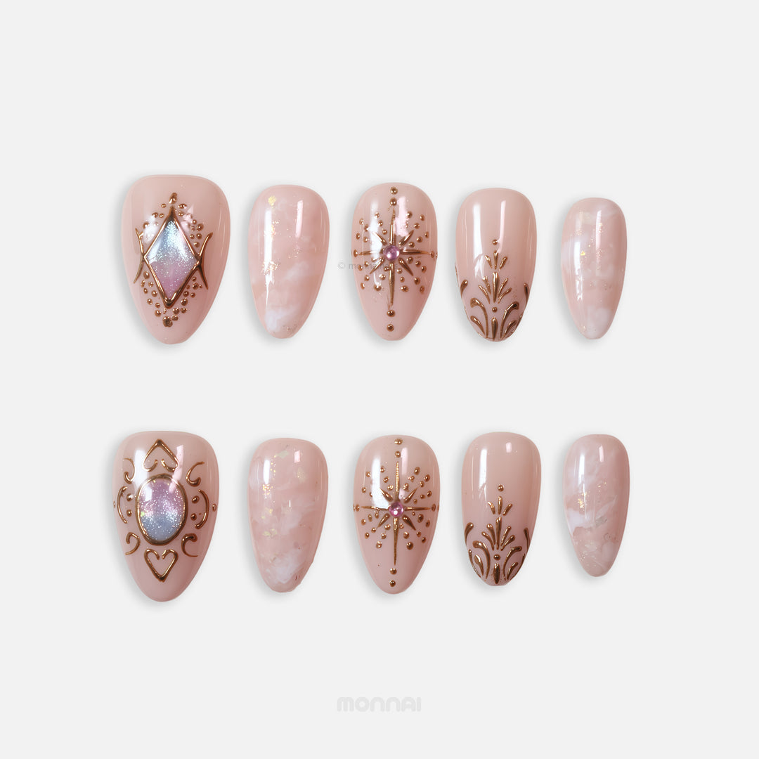 Blush Crown press-on nails in celestial style, showing ornate blush nude nails with gold line art, marbling, and gem accents