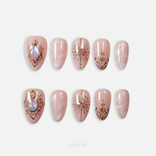 Blush Crown press-on nails in celestial style, showing ornate blush nude nails with gold line art, marbling, and gem accents