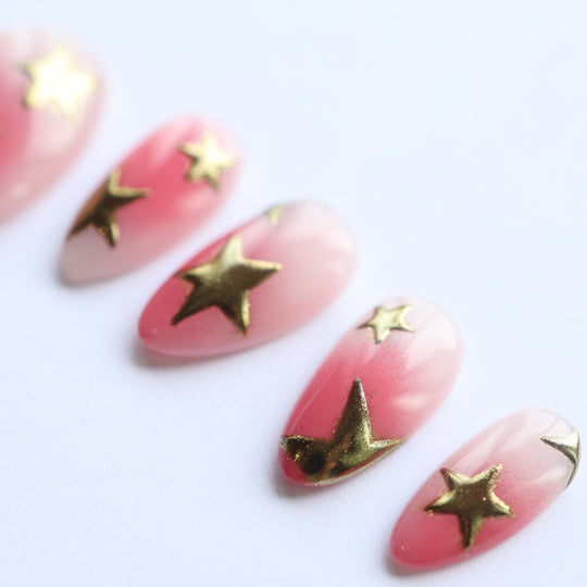 Blush Star press-on nails laid out with pink blush gradients and metallic gold stars