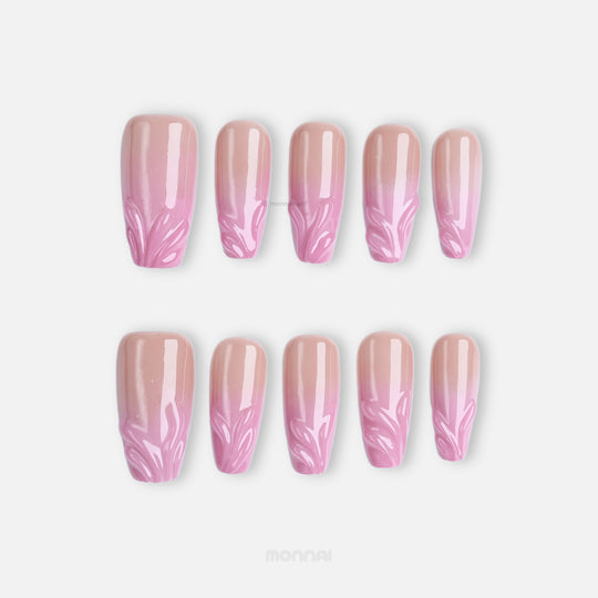 Blush Swirl press-on nails with sheer nude-to-pink fade and raised gel details at the tips, laid out in two rows.