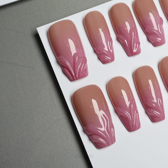 Blush Swirl press-on nails laid out with nude-to-pink fade and raised gel tips