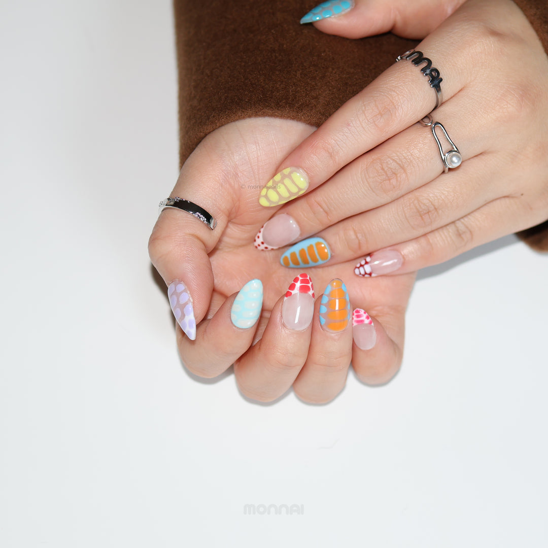 Bold Vibes press-on nails on hands, colorful crocodile-print and glossy polka dot patterns with playful gradients