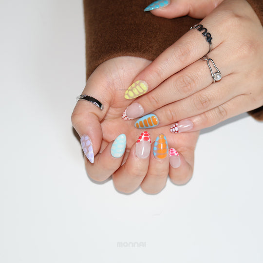 Bold Vibes press-on nails on hands, colorful crocodile-print and glossy polka dot patterns with playful gradients