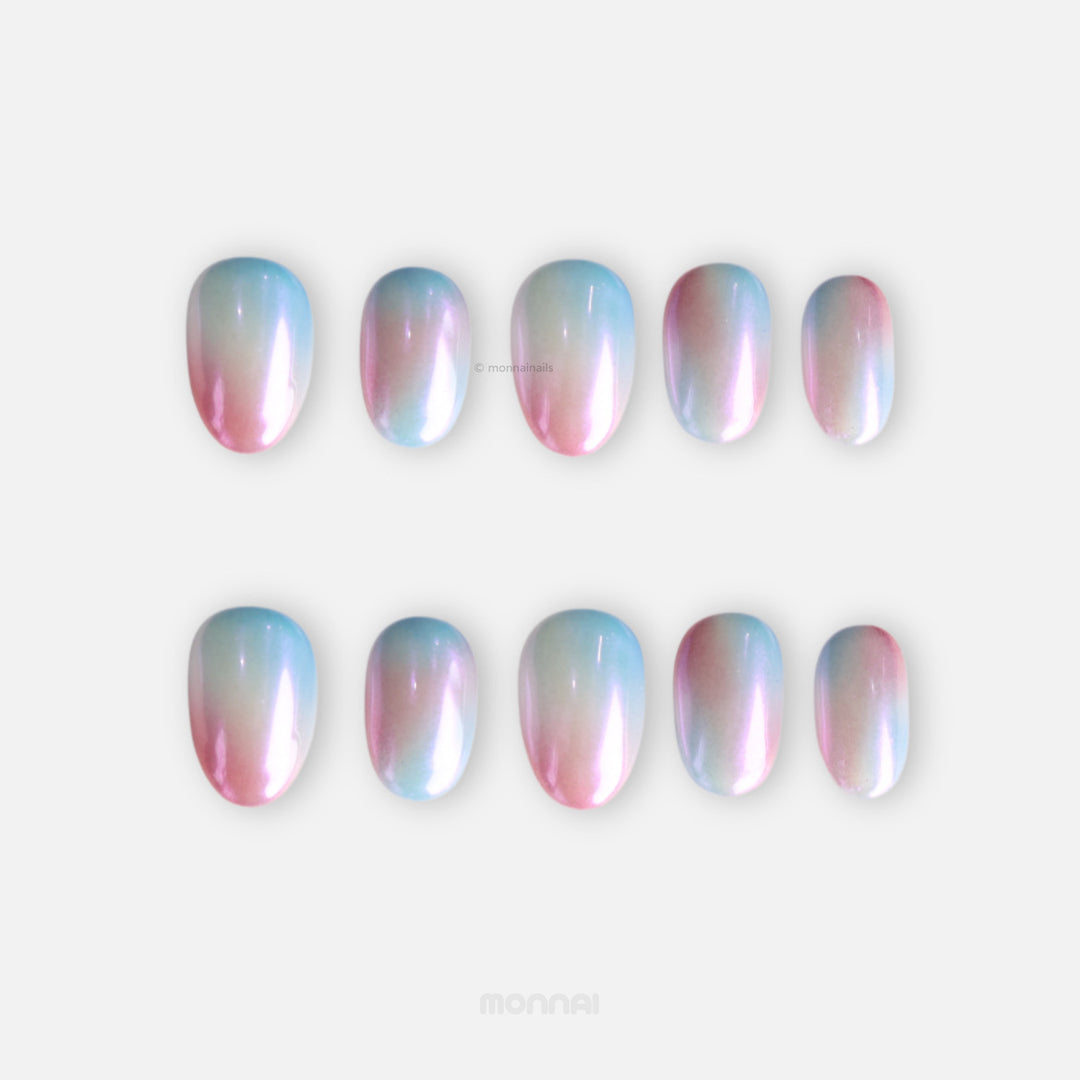 Candy Sky press-on nails shown in two rows, featuring pastel blue-to-peach ombre with an iridescent pearl shine.