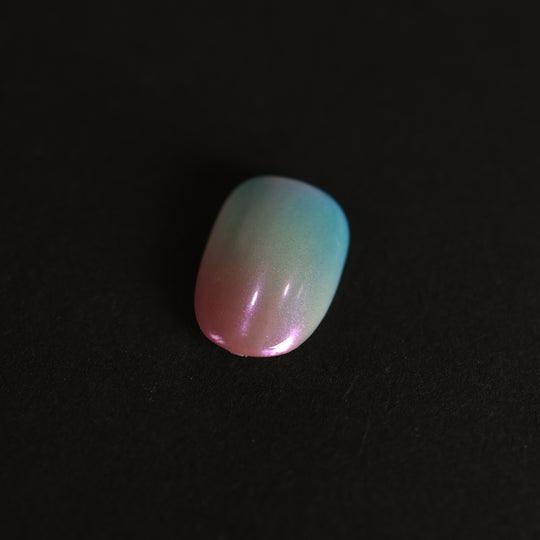 Candy Sky press-on nails in dreamy pastel blue-to-peach ombre with an iridescent pearl glaze, shown in close-up.