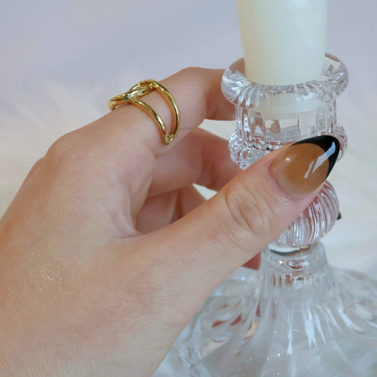 Caramel Edge press-on nails with warm nude base, black French tips, shown worn on hand