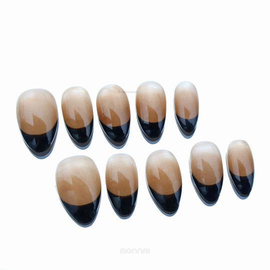 Caramel Edge press-on nails with warm nude base and crisp black French tips, shown laid out in glossy close-up.