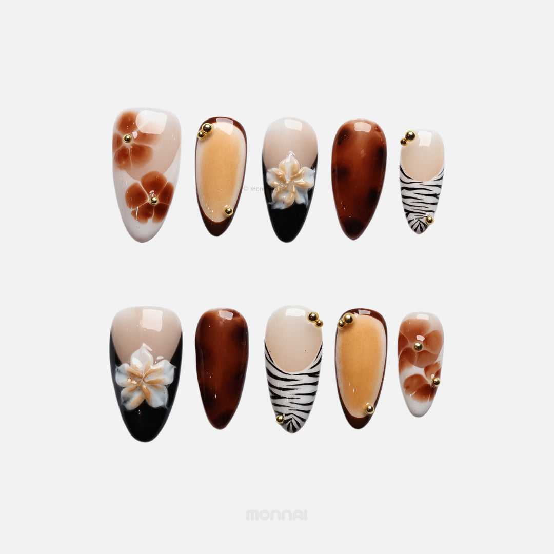 Caramel Flora press-on nails laid out in earthy vintage-inspired florals, zebra tips, gold beads and gel-gloss finish.
