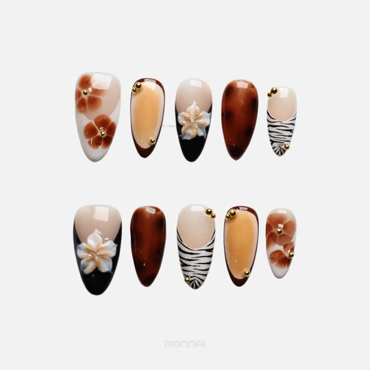 Caramel Flora press-on nails laid out in earthy vintage-inspired florals, zebra tips, gold beads and gel-gloss finish.