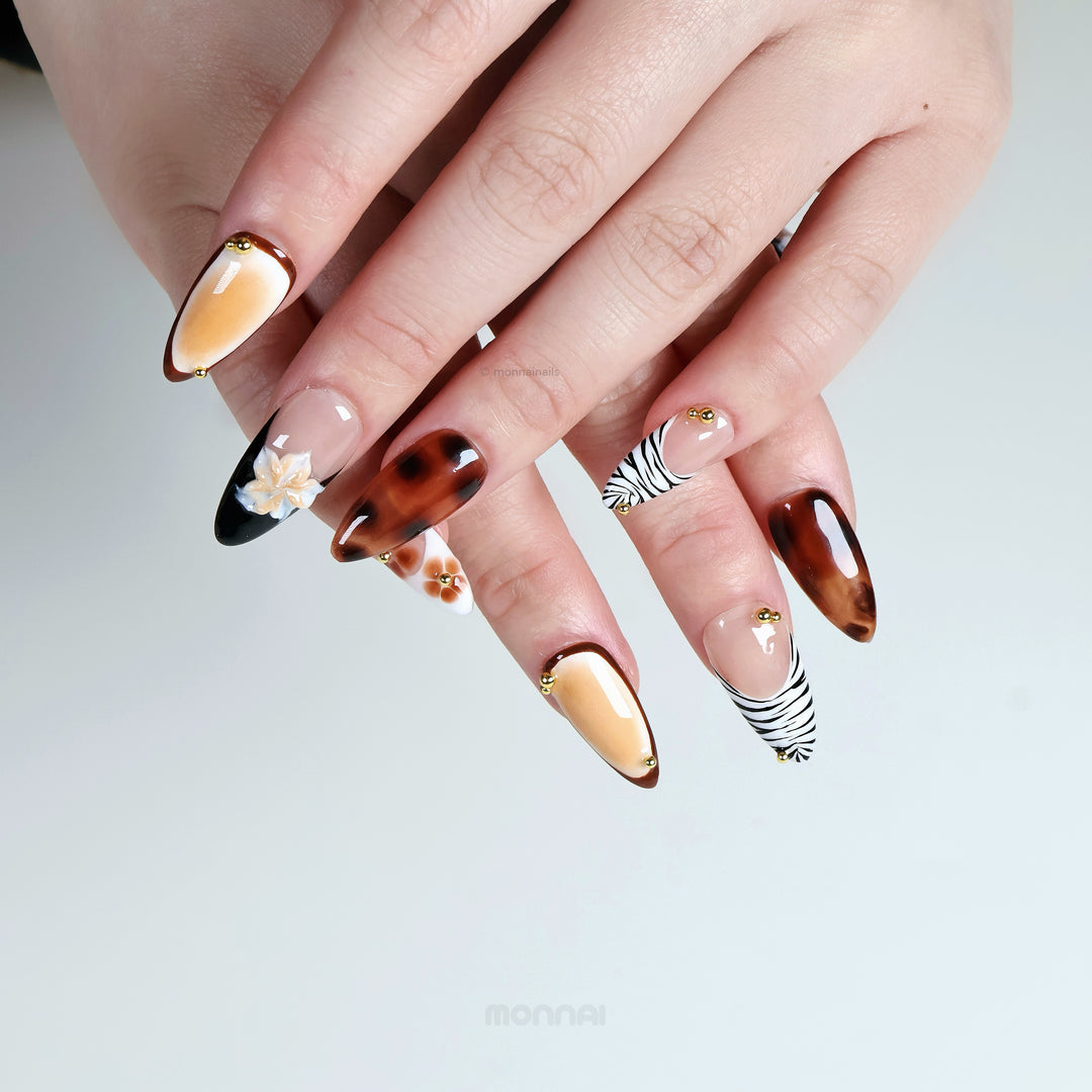 Caramel Flora press-on nails worn on hands, earthy vintage-inspired set with tortoiseshell, zebra tips, florals and gold beads