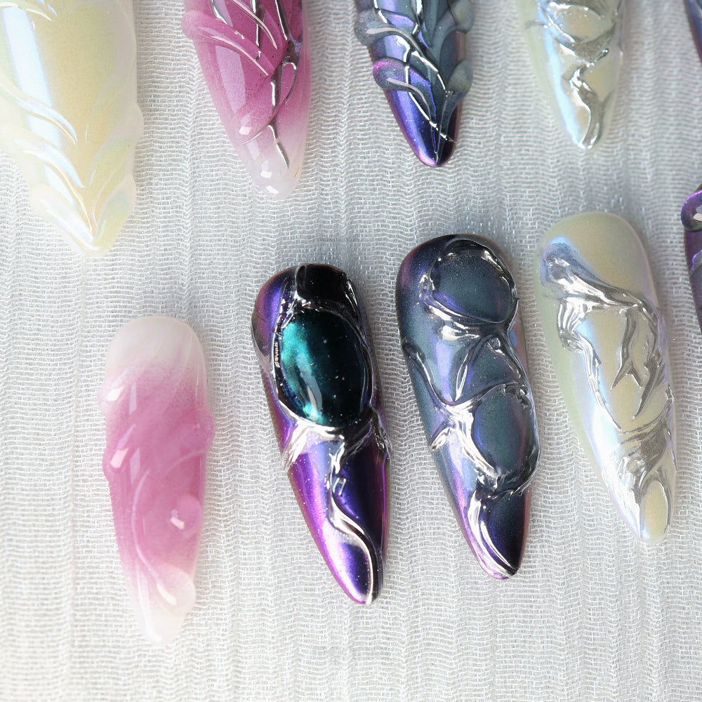 Celestial Aurora press-on nails laid out with iridescent white, violet-blue, and soft pink chrome accents