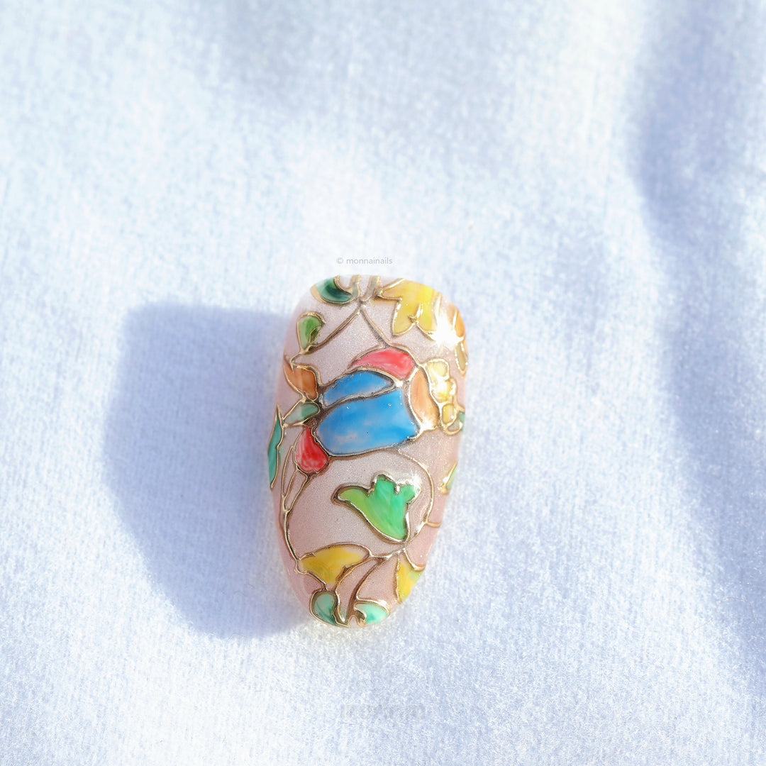 Chapel Garden press-on nails close-up, stained-glass floral mosaic with blue, green and yellow panels