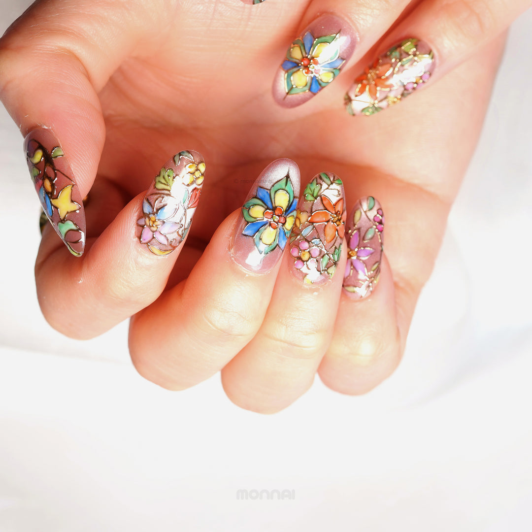 Chapel Garden press-on nails shown on hand, with jeweled floral mosaic details and cat-eye shimmer.