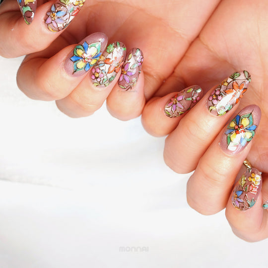 Chapel Garden press-on nails worn on hands, with jeweled floral mosaic details and dark outlines on a shimmering base.