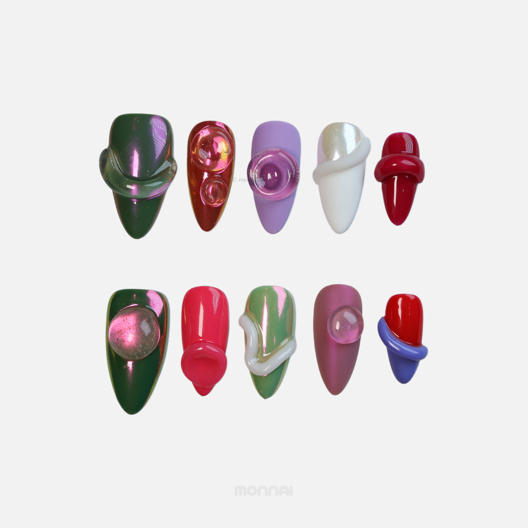Chic Curves press-on nails laid out in a playful, avant-garde mix of iridescent chrome, glossy colors, and 3D gel textures.