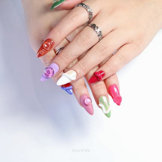 Chic Curves press-on nails worn on hand, showing sculptural abstract multi-color 3D gel textures with glossy finishes.