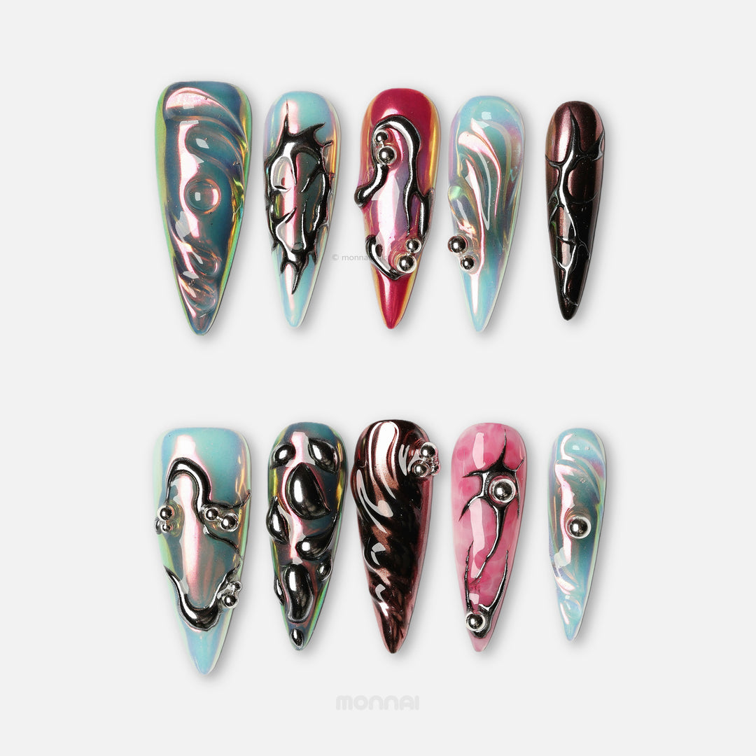 Chrome Wave press-on nails laid out in iridescent blue, pink and chrome with raised metallic curves.