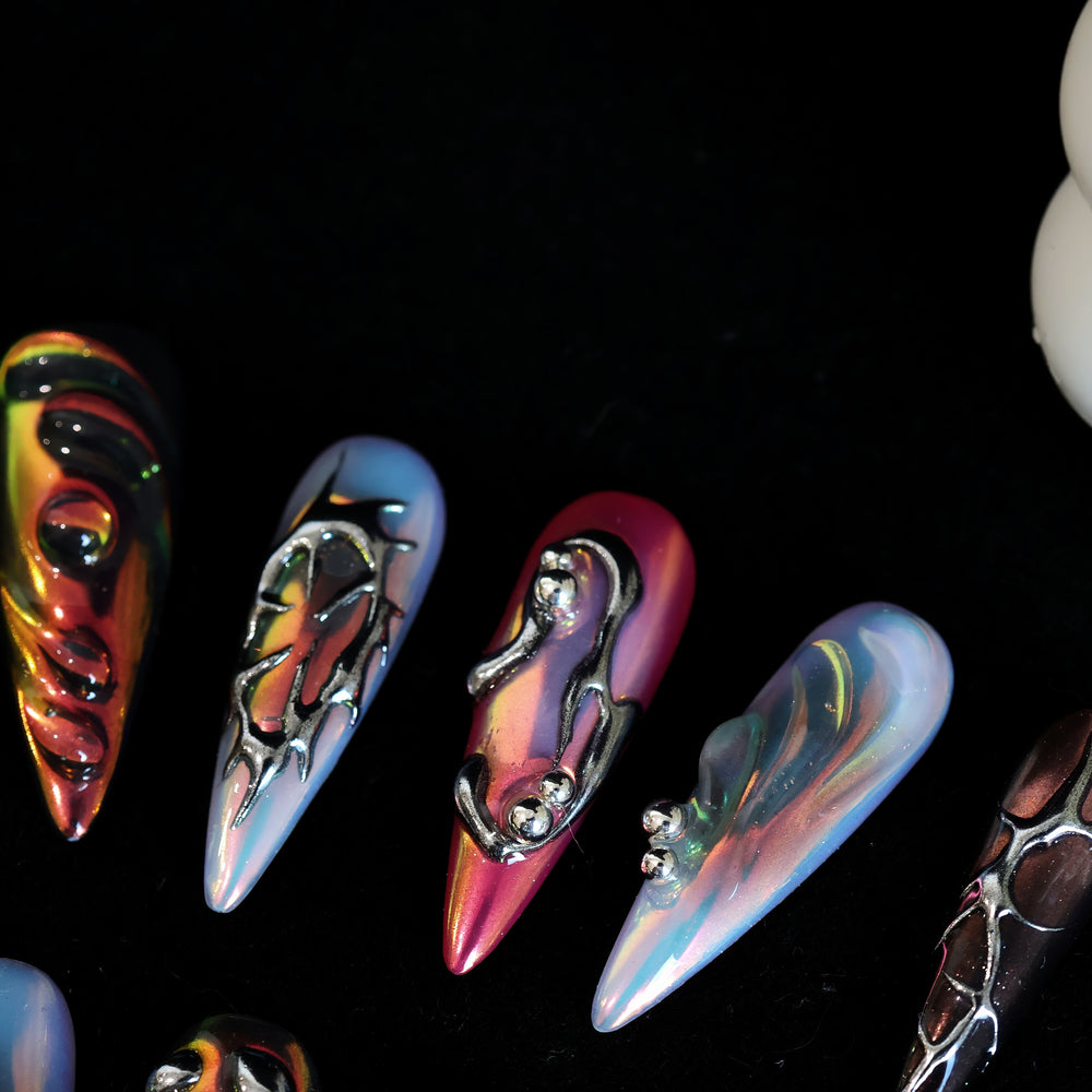 Chrome Wave press-on nails with iridescent blue, pink and chrome raised details, shown laid out in close-up