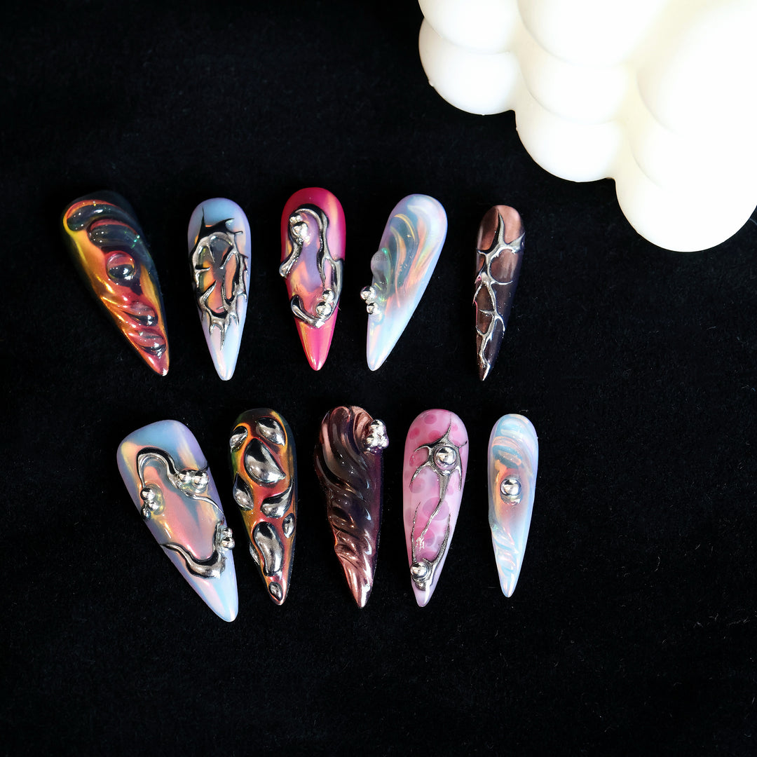Chrome Wave press-on nails displayed in close-up, with iridescent blue, pink and chrome metallic curves.