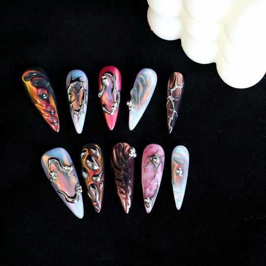 Chrome Wave press-on nails displayed in close-up, with iridescent blue, pink and chrome metallic curves.